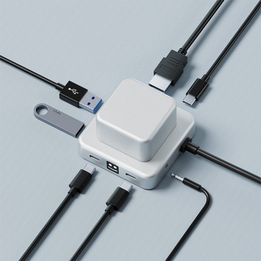 Silberner CUBBI-Hub mit angeschlossenen HDMI-, USB-A- und USB-C-Kabeln, USB-Stick und Audiokabel