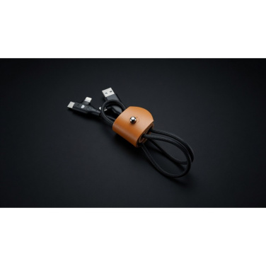 Cognacfarbenes Lederband hält schwarzes Kabel mit USB-A- und USB-C/Lightning-Stecker