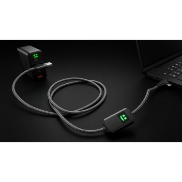 Pack Allure Wandladegerät und geflochtenes Kabel mit grünen Smiley-Leuchten neben einem Laptop