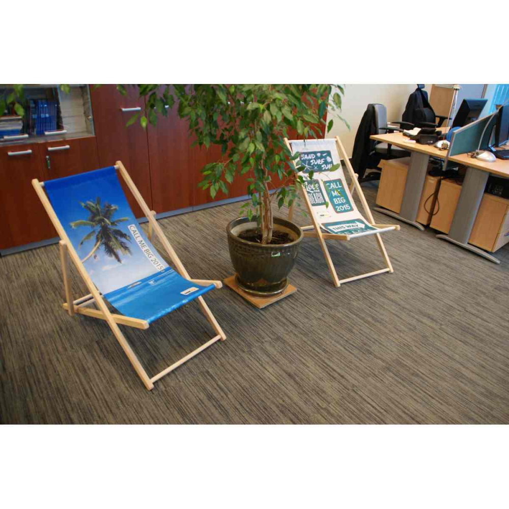 Zwei Holz-Liegestühle mit Palmen- und Strandmotiv in einer Büro-Lounge-Ecke