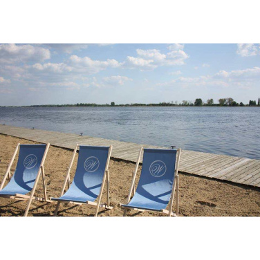 Drei hellblaue Liegestühle mit Monogramm am Sandstrand eines Sees