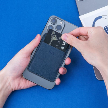 Blue INÉ Mini card holder on a phone, hand pulling a bank card from the slot, blue background