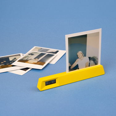 Keltainen Le19-valokuvateline ja lämpömittari polaroidkuvalla, vieressä kuvia sinisellä taustalla