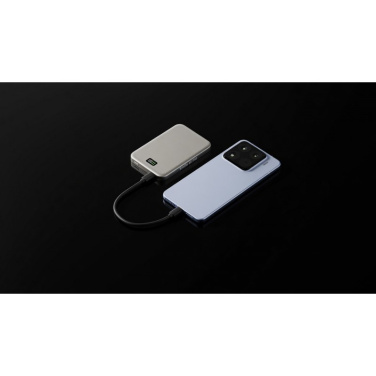 Hopeanvärinen Solid Smile -varavirtalähde kytkettynä USB-C-kaapelilla vaaleansiniseen puhelimeen