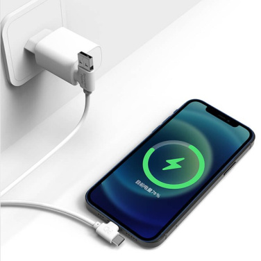 Белая зарядка Xoopar Bolt в розетке заряжает смартфон через кабель