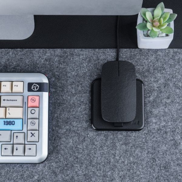 INÉ Everyday på grå filtunderlägg bredvid tangentbord och växt, med en enhet ovanpå