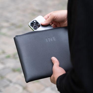 Svart INÉ-fodral i handen medan en smartphone stoppas ner